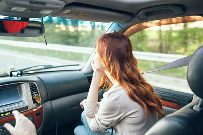 Rear view of woman sitting in car