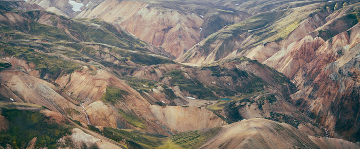 Mossy volcanic hills in iceland's highlands with emerald lake, creek