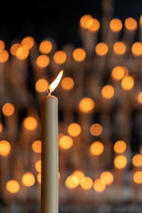 Close-up of illuminated candles against temple