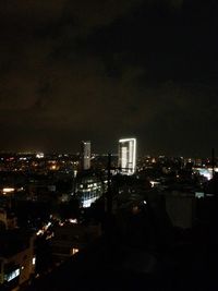 Illuminated cityscape against sky at night