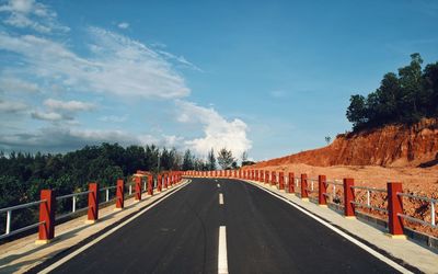 Road amidst trees against sky