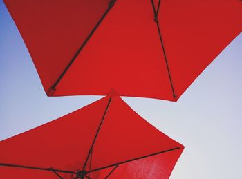 Low angle view of red umbrella against clear sky