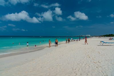 People at beach against sky