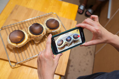 Midsection of woman using smart phone on table