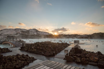 Scenic view of thermal spa by mountians during sunset