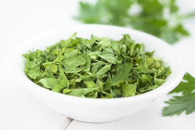 Close-up of green leaves in bowl on table