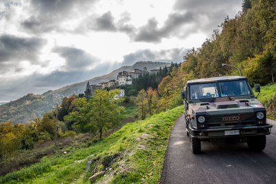 Car on road by mountain against sky