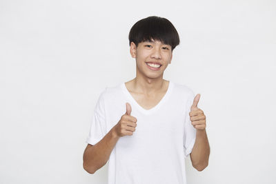 Portrait of smiling man standing against white background