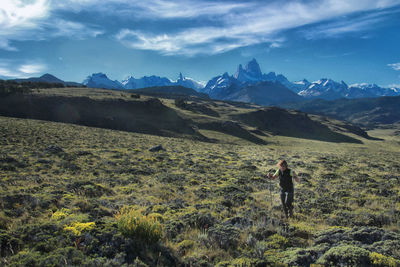 Woman climbing on mountain against sky