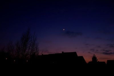 Low angle view of silhouette trees against sky at night