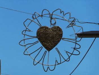 Low angle view of heart shape against clear blue sky