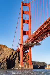 Golden gate bridge over sea against clear blue sky