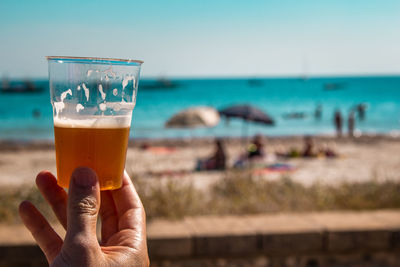 Hand holding glass of beer