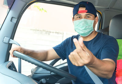 Portrait of young man sitting in car