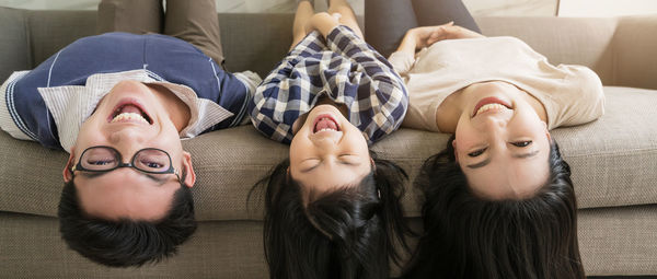 Portrait of young woman lying on sofa at home