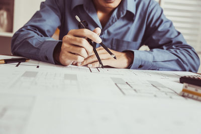 Midsection of architect working at office