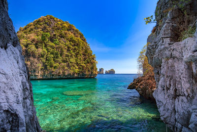 Scenic view of sea and rocks against blue sky