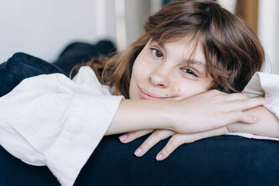 Portrait of young woman lying on bed at home