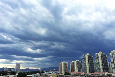 Cityscape against cloudy sky