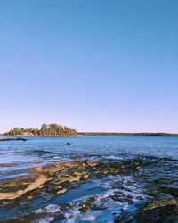 Scenic view of sea against clear blue sky