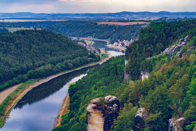 Scenic view of river amidst green landscape against sky