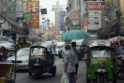 People and vehicle on road in city