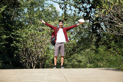 Full length of man jumping against trees