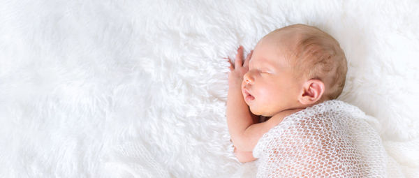 Cute baby girl sleeping on bed at home