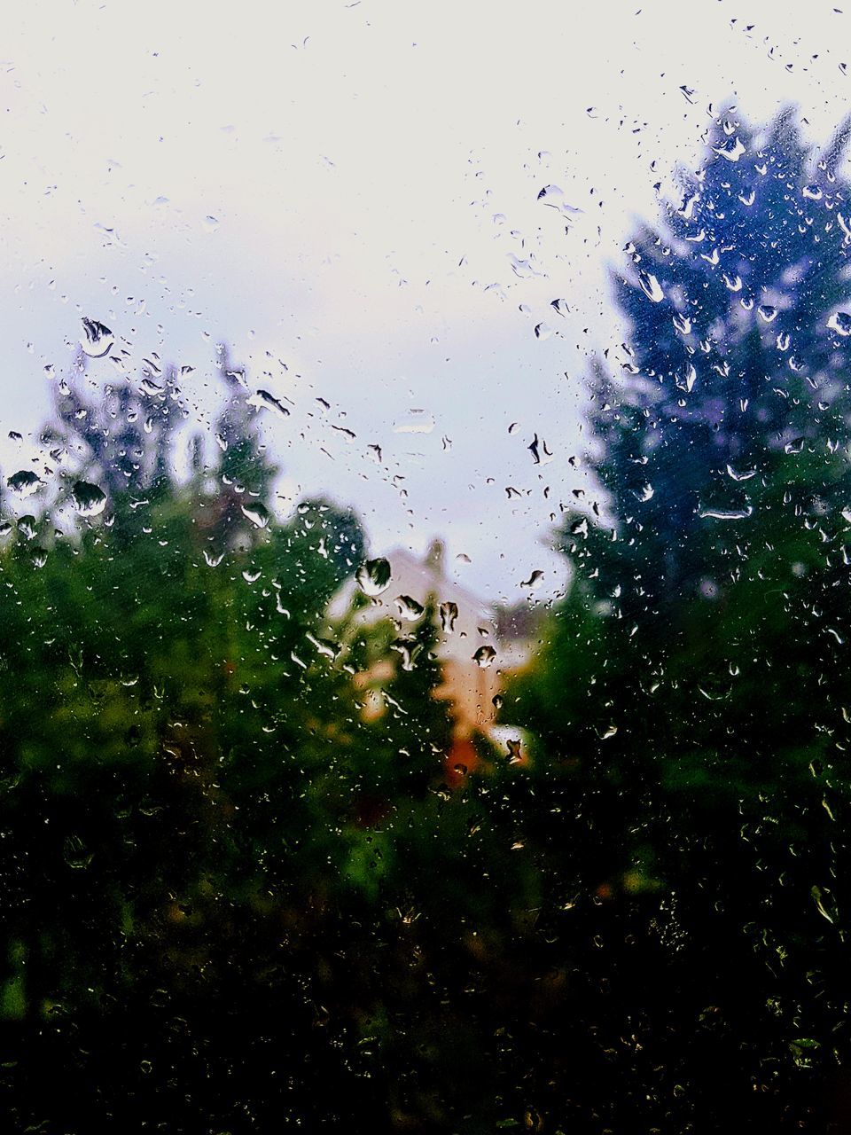 RAINDROPS ON GLASS WINDOW AGAINST SKY