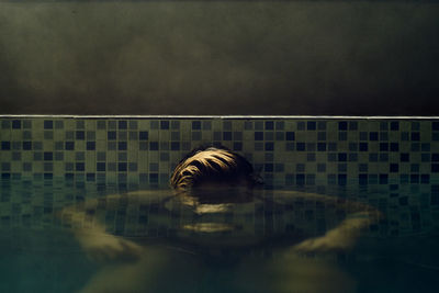 Portrait of swimming in lake against buildings