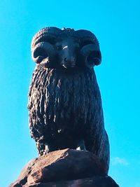 Low angle view of eagle statue against clear blue sky