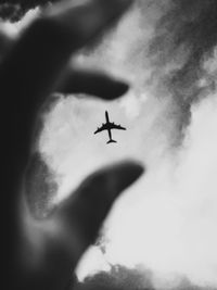 Low angle view of airplane flying against sky