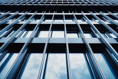 Low angle view of glass building against sky