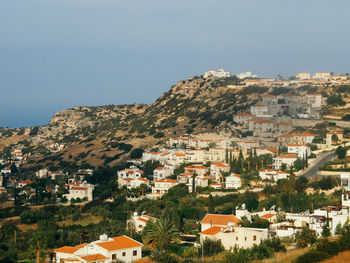 Houses in town on cliff against sky