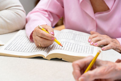 Midsection of woman writing in book