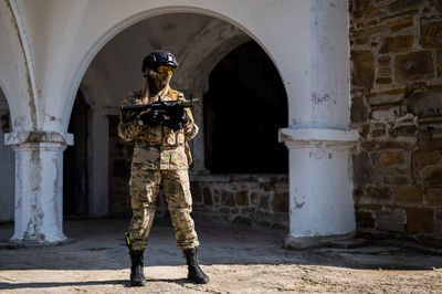 Army soldier with rifle against building