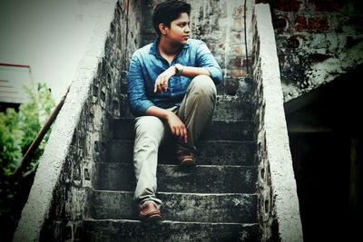 Young man sitting on staircase