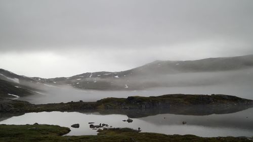 Scenic view of lake and mountains against sky