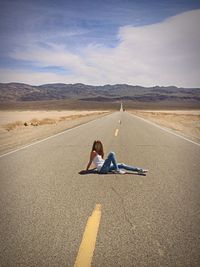 Woman sitting on road