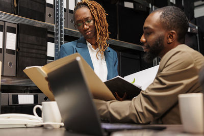 Side view of woman using laptop at office