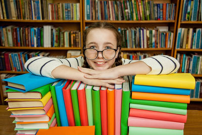 Girl in glasses with books in the library.