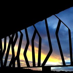 Low angle view of silhouette metal structure against sky during sunset