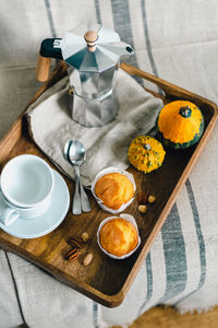 Morning coffee with pumpkin muffins on a wooden tray.