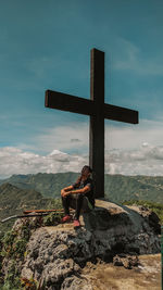 Man on cross against sky