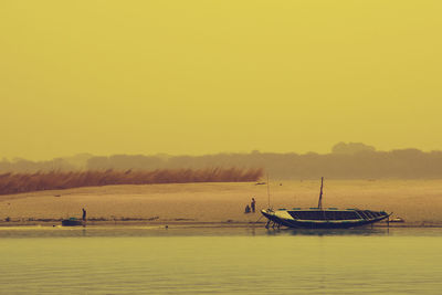 Boat in sea against clear sky during sunset