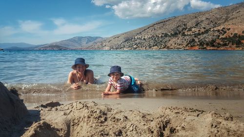 Portrait of mother and son lying on shore