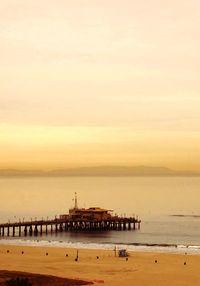 Pier over sea against sky during sunset