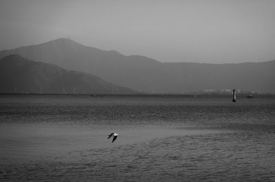 Scenic view of sea and mountains against sky