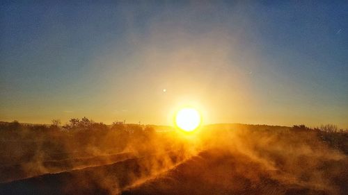 Scenic view of landscape against clear sky during sunset