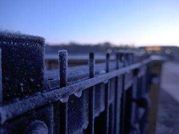 Close-up of wooden post during winter against sky